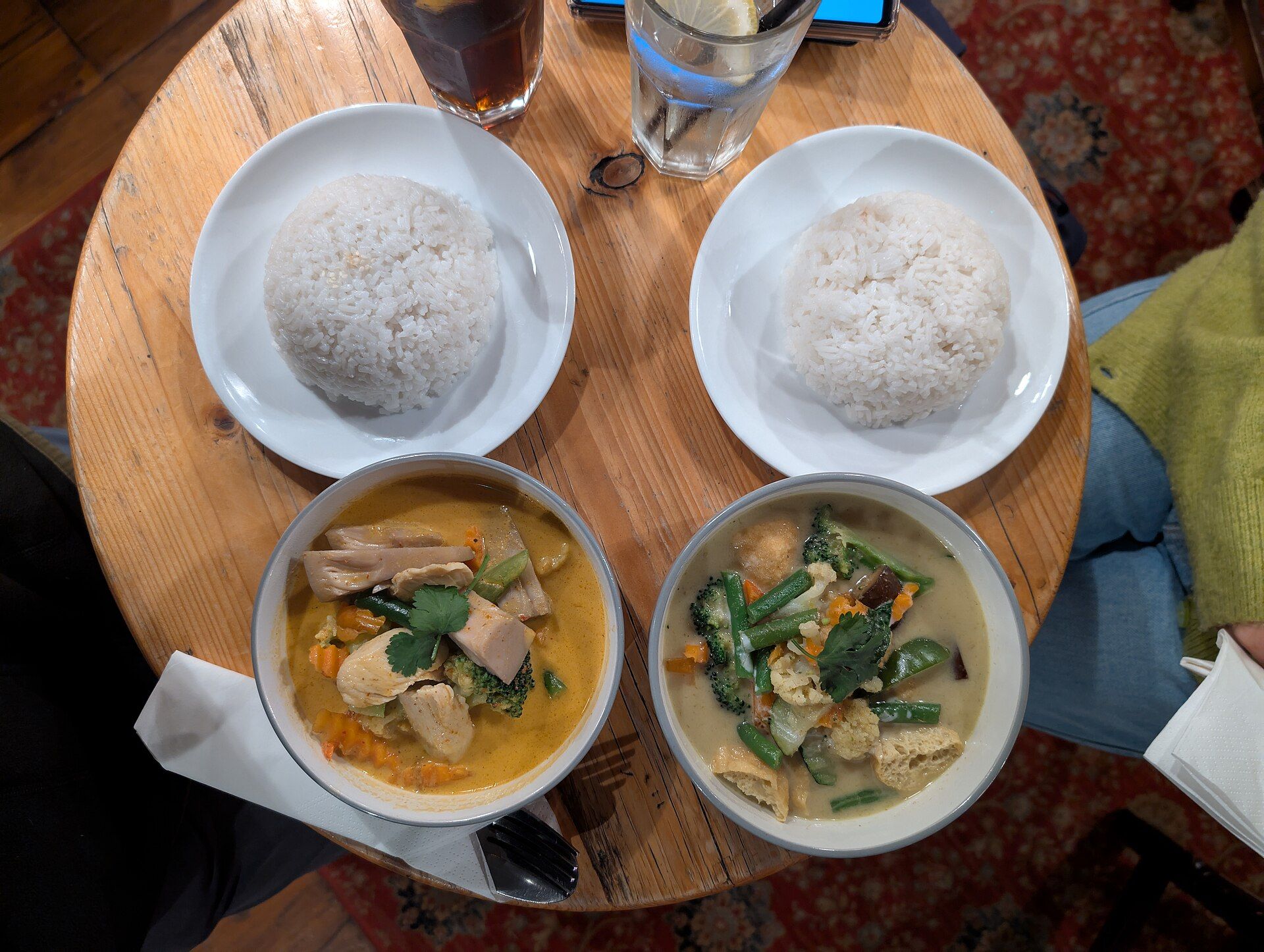 Deux currys thaïs et du riz blanc, vus du dessus sur une table en bois
